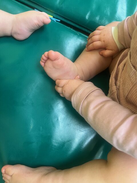 Detalle de los pies de un bebé durante un taller de masaje infantil y estimulación sensorial en la Escuela Infantil La Casita