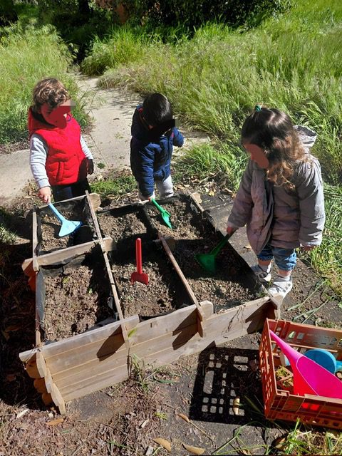 Niños de la Escuela Infantil La Casita plantando semillas en el huerto escolar en Torrejón de Ardoz.
