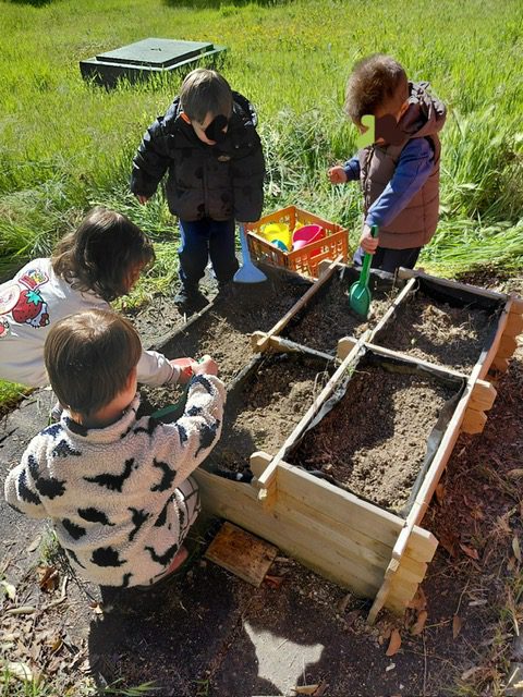 Niños de la Escuela Infantil La Casita plantando semillas en el huerto escolar en Torrejón de Ardoz.
